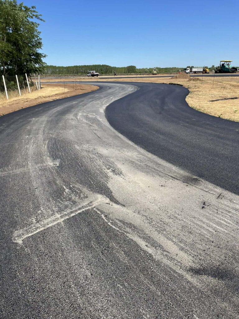 Kanyarodó új aszfaltút szántóföld mellett