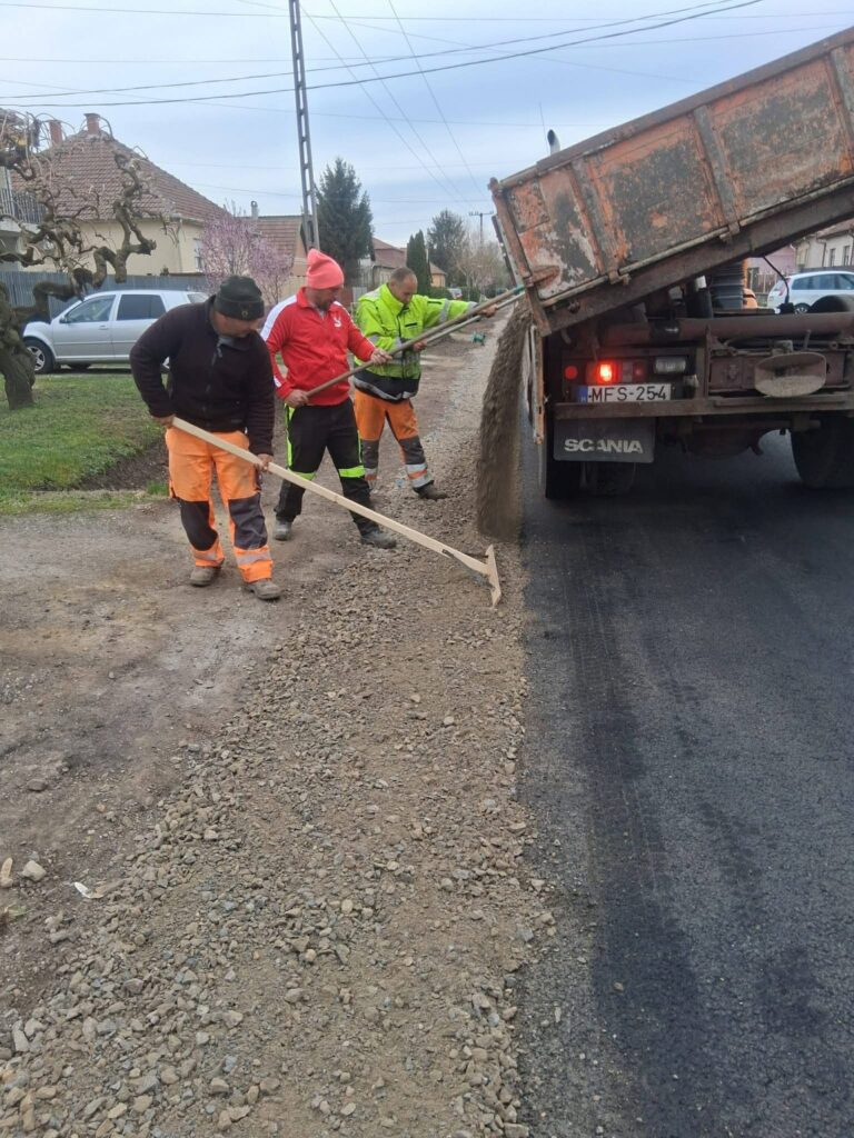 Aszfaltterítés billenős teherautóból utcán