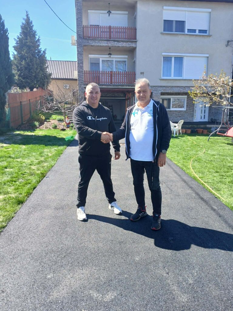 Az elkészült aszfalt bejáró a ház előtt, kézfogással