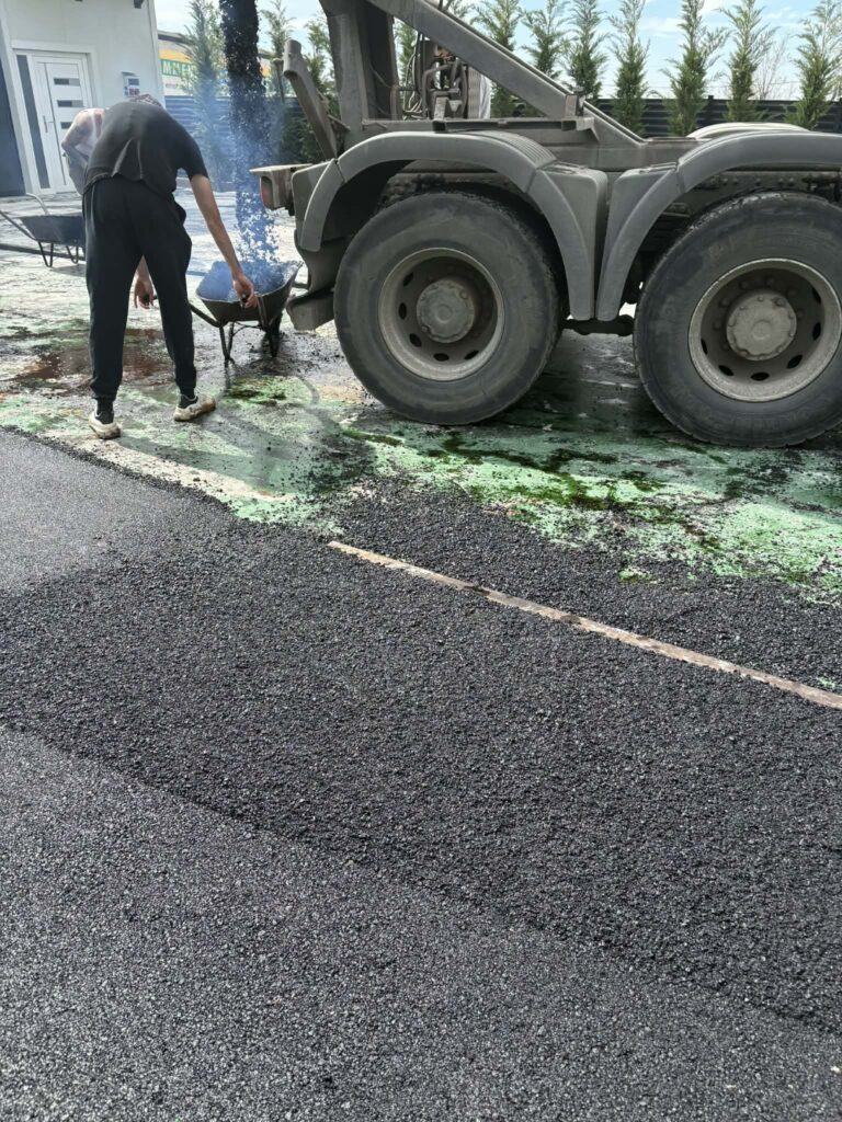 Aszfalt bedolgozása a teherautó mellett