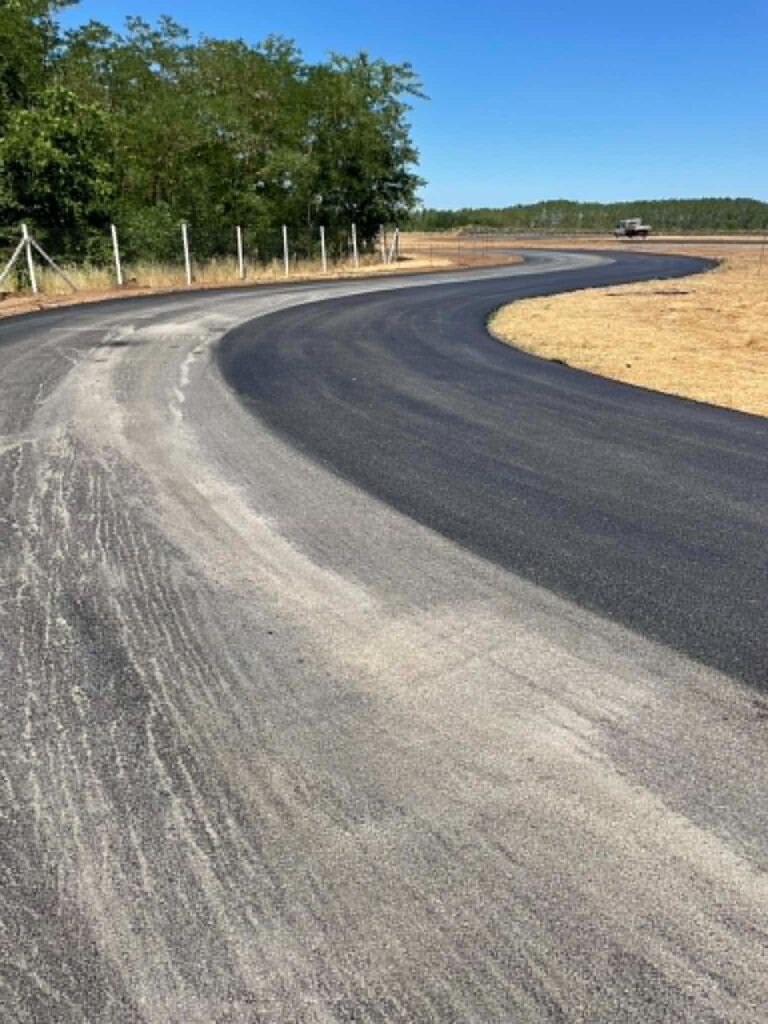 Új aszfaltburkolat kanyarral, nyári napsütésben